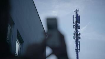 A person seen utilizing a smartphone while surrounded by an urban backdrop in a city setting video
