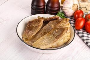 A bowl of fish with tomatoes and other ingredients photo