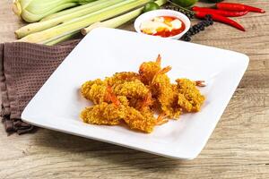 A plate of fried shrimp on a table with other food photo