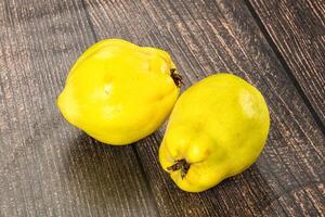 Two yellow fruits on a wooden table photo