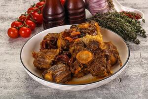 A bowl of meat and vegetables on a table photo