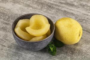 A bowl of peeled quinces and a leaf photo