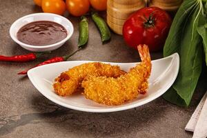 Fried shrimp on a plate with sauce and vegetables photo