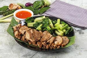 A plate of meat and vegetables with sauce photo