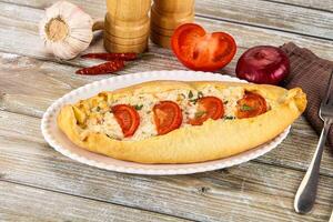 A bread roll with tomatoes and cheese on it photo