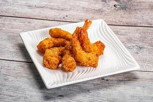 A plate of fried shrimp on a wooden table photo
