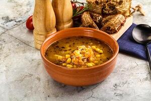 A bowl of soup with a spoon and a knife photo