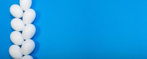 a row of eggs beautifully arranged on a blue background, top view, space for text photo