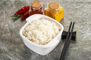Rice in a bowl with chopsticks and spices photo
