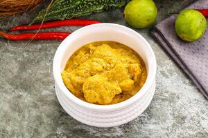 A bowl of curry with some vegetables and a knife photo