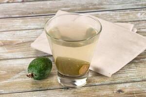 A glass of water with a lime and a piece of avocado photo