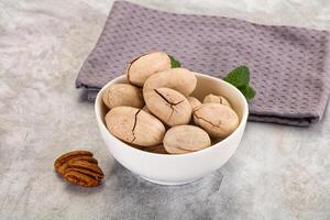 Pecan nuts in a bowl on a gray background photo