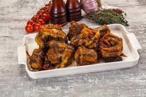 A white dish with meat and vegetables on it photo