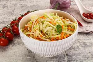 A bowl of coleslaw with tomatoes and onions photo