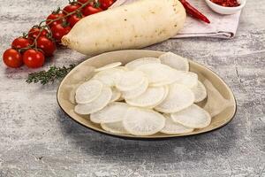 A bowl of sliced radishes and tomatoes on a table photo