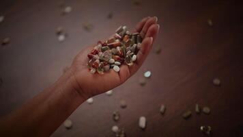 A Handful of Pills Displayed on a Wooden Surface, Ready for Nutritional and Health Benefits video