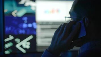 A dedicated professional in technology monitoring on call who manages multiple screens effectively video