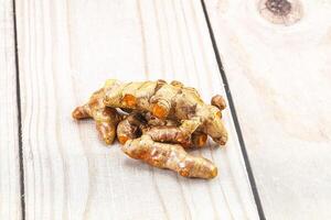 A pile of ginger on a wooden surface photo