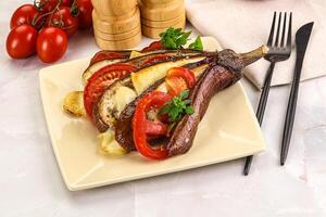 A plate with a steak, vegetables and a knife and fork photo