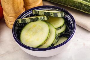 A bowl of sliced cucumbers on a counter photo