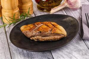 A plate with a piece of meat on it photo