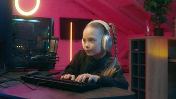 Concentrated gamer little girl user enjoy late evening streaming talking to microphone daughter kid child playing computer virtual online gaming car auto driving modern game streamer at home video