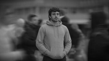 A solitary figure found within a bustling crowded urban scene, creating a striking contrast video