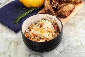 A bowl of food with crab and lemons photo