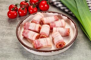 Bacon wrapped in bacon on a plate with tomatoes photo