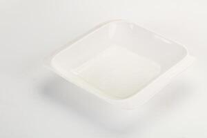 A white square dish with a lid on a white surface photo