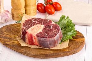 A piece of meat on a cutting board with a knife photo