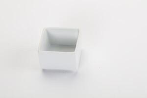 A white square container with a lid on a white surface photo