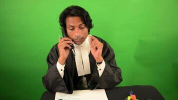 Pleader busy at his desk handling a client call video