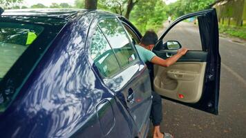 Man getting down from parked car with mobile in hand video