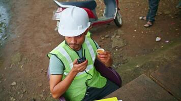 Engineer sips tea and talks through wireless device video