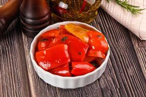 A bowl of peppers and a bottle of olive oil photo