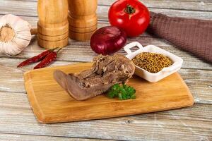 A wooden cutting board with meat, spices and vegetables photo
