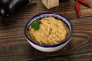 A bowl of hummus with some vegetables and spices photo