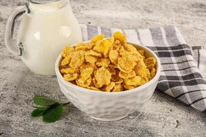 A bowl of cereal next to a glass of milk photo