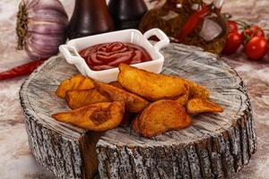 A plate with some potatoes and ketchup photo