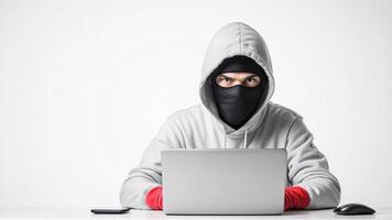Masked hacker using laptop, serious expression. photo