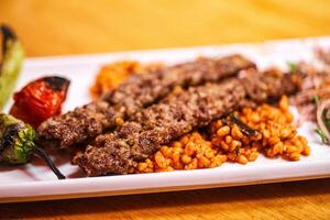 A plate of meat and rice with vegetables on it photo