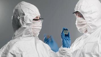 Close-up of a design engineer in a sterile jumpsuit inspecting a microchip with gloved hands in a state-of-the-art electronics factory, perfect for showcasing advanced tech and precision engineering video