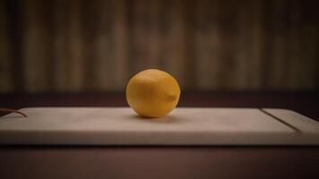 A Fresh Lemon resting on a Cutting Board surrounded by a Rustic Background that enhances its beauty video