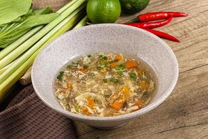 A bowl of soup with vegetables and herbs photo