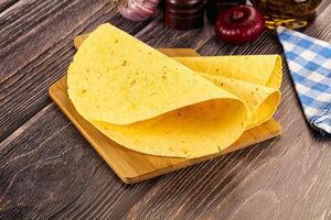A tortilla on a cutting board with some spices photo