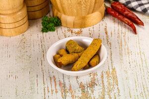 A bowl of food on a table next to a wooden cutting board photo