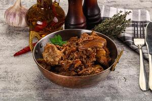 A bowl of meat and vegetables on a table photo