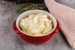 A red bowl filled with mashed potatoes and herbs photo