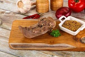 A wooden cutting board with meat, spices and vegetables photo